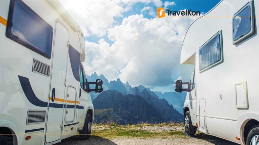 a couple of white rvs parked on a mountain side